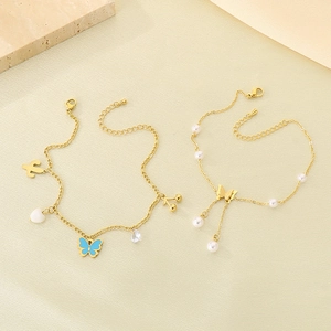 Chic butterfly anklet set with tassels, rhinestones, and pearls on textured stone
