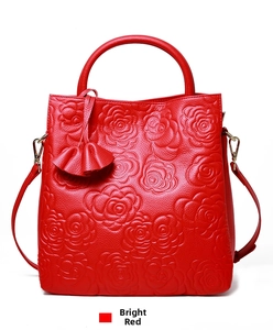 Dettaglio borsa rossa in pelle con rose a rilievo e ciondolo con nappa decorativa