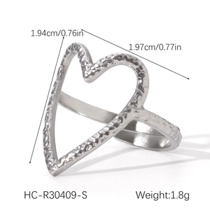 Macro shot of a silver heart-shaped open ring showing hammered texture and dimensions