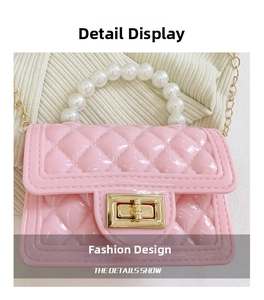 Close-up of pink quilted jelly bag with pearl handle and golden twist lock detail