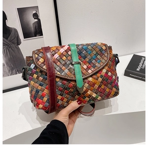 Gros plan sur le motif en cuir tressé coloré et la boucle métallique du sac oreiller