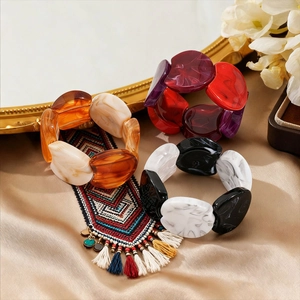Retro acrylic marbled geometric bangle set in orange and burgundy on silk background