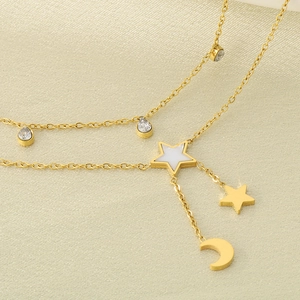 Détail d'une chevillère dorée double épaisseur avec breloques étoile et lune sur soie
