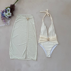 Detail of swimsuit set with mesh cover-up skirt featuring gold starfish buckles