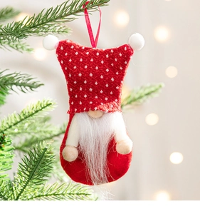 Close-up of a red and white gnome ornament hanging on a Christmas tree branch