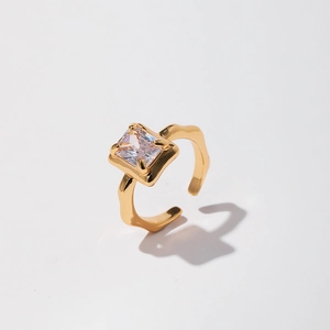 Detailed macro view of square zircon stone in a gold wave-textured adjustable open ring