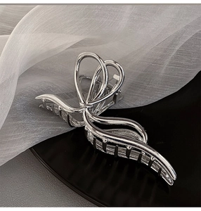 Detailed view of large silver metal butterfly hair claw clip with twisted design