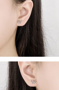 Detail view of dainty silver V-shaped stud earrings with micro-inlaid cubic zirconia