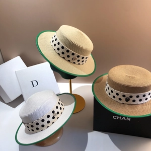 Flat top straw boater hats with green trim and polka dot ribbons on elegant displays