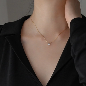 Elegant gold titanium steel necklace with a single round cut zircon pendant on a model
