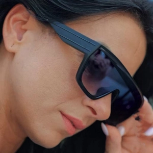 Close-up of oversized black square sunglasses on model highlighting side frame fit