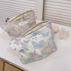 Detailed view of butterfly jacquard fabric and metal zipper on canvas makeup pouch