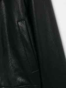 Detailed macro view of the pocket and fine stitching on a black leather biker jacket