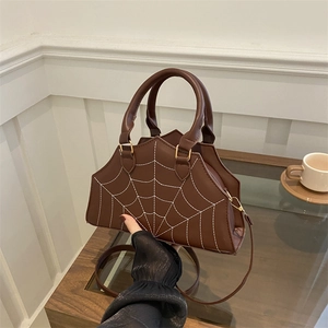 Brown coffin-shaped handbag with white spider web stitching and long shoulder strap