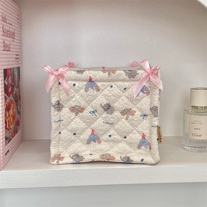 Close-up of quilted storage basket with elephant patterns and pink silk bow decorations