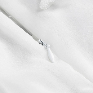 Detailaufnahme eines weißen Reißverschlusses an einem eleganten ärmellosen Kleid