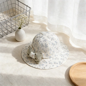 Détail d'un chapeau de soleil bébé avec imprimé fleuri bleu et nœud lapin peluche