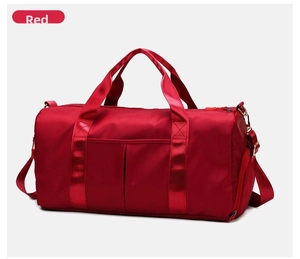 Detail view of the red gym bag showing front storage compartment and durable strap