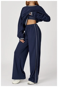 Détail du pantalon de sport large bleu marine avec rayures blanches et taille haute élastique