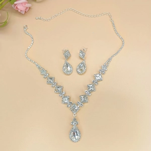 Silver bridal jewelry set featuring teardrop crystal necklace and matching earrings