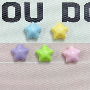 Macro shot of colorful resin star beads in blue yellow purple green and pink for DIY crafts
