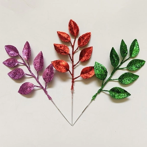 Glittery artificial Christmas leaves in purple, red and green for DIY wreath decoration
