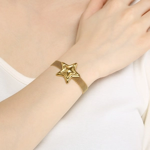 Close-up of golden stainless steel mesh bracelet featuring a polished star charm