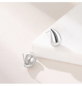 Macro shot of silver teardrop stud earrings showing front and back closure details