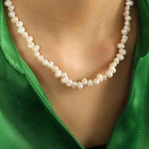 French vintage freshwater pearl necklace with baroque beads on green satin background