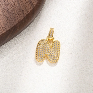 Detailed close-up of a gold-plated letter N pendant with pavé cubic zirconia inlay