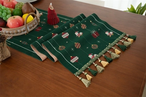 Detail of Christmas table runner with snowman, gift box motifs and fringed tassels