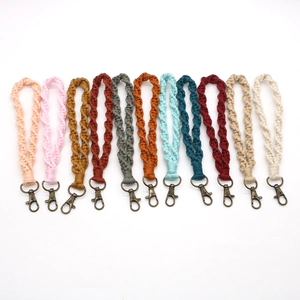 Dettaglio di cinturini boho intrecciati a mano con chiusure a moschettone in bronzo