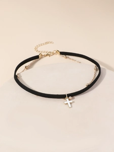 Dettaglio di choker in velluto nero con catena a sfere dorate e ciondolo a croce
