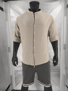 Detail of men's beige cotton linen shirt with stand collar and rolled-up sleeves texture