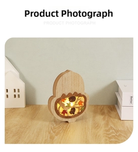 Detail showing an acorn-shaped wooden night light with warm LED forest scene carving