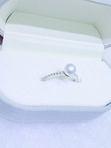 Close-up of a 6-7mm white freshwater pearl ring with zircon accents in a velvet box