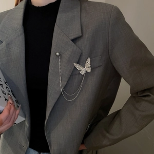 Detail of silver butterfly chain brooch pinned on a grey suit lapel for a chic style