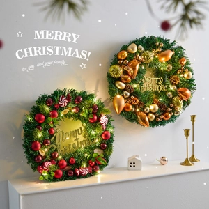 Artificial Christmas wreaths with pine needles, ornaments, and warm LED lights on a white mantel