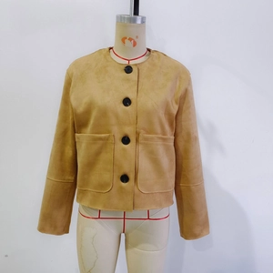 Détail de la veste en daim camel avec gros boutons noirs et poches carrées plaquées