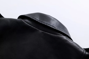 Close-up of black faux leather motorcycle jacket showing premium shoulder stitching and texture
