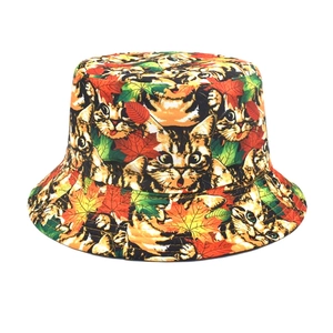 Detail of double-sided bucket hat featuring cartoon cat and autumn maple leaf patterns