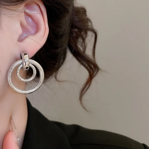 Vue détaillée de boucles d'oreilles argentées à double cercle avec texture polie