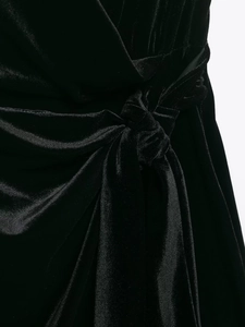 Detail des Knotendesigns und der Faltenstruktur an diesem schwarzen Samtkleid