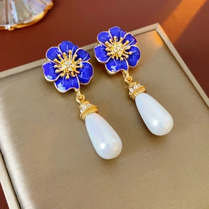 Makroaufnahme blauer Emaille-Blumenohrringe mit Kristallen und Perlenanhängern