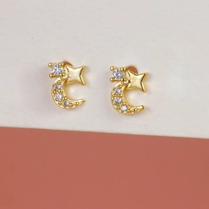 Elegant gold-plated star and moon earrings with white zircon on a minimalist background
