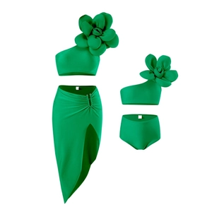 Detailed view of emerald green three-piece swimwear with a large 3D floral accent