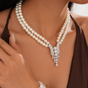 Detail of elegant double-layer faux pearl necklace with geometric rhinestone pendant