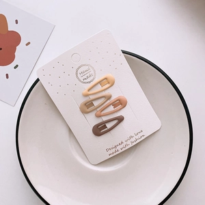 Set of four matte milk tea colored hair clips in cream and brown on a white card display