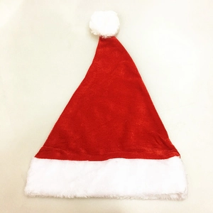 Close-up of a red plush Santa hat with a white faux fur trim and fluffy pompom detail
