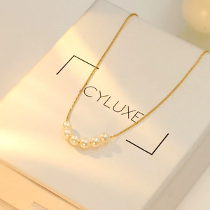 Close-up of a minimalist 18k gold-plated necklace featuring six elegant white pearls